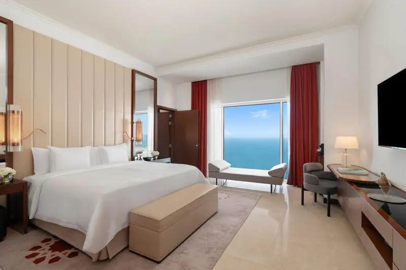 Une chambre lumineuse avec un grand lit et une vue sur la mer.