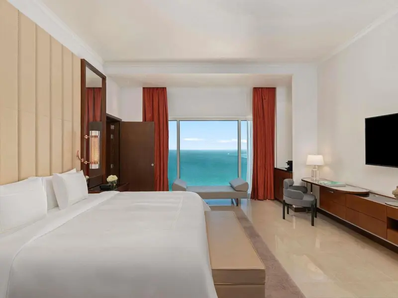 Une chambre lumineuse avec un grand lit et une vue sur la mer.