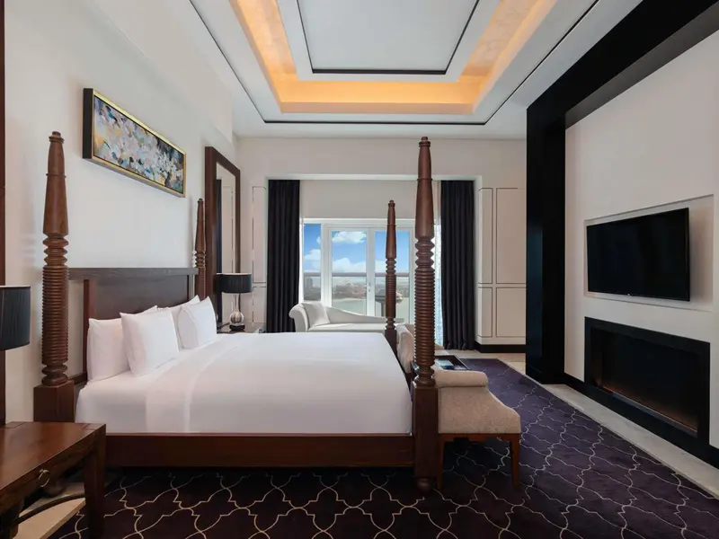 Une chambre spacieuse avec un grand lit à baldaquin et une décoration soignée.