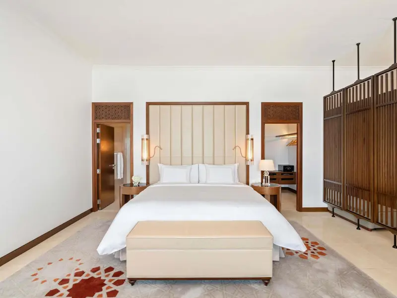 Une chambre lumineuse avec un grand lit et une décoration sobre.