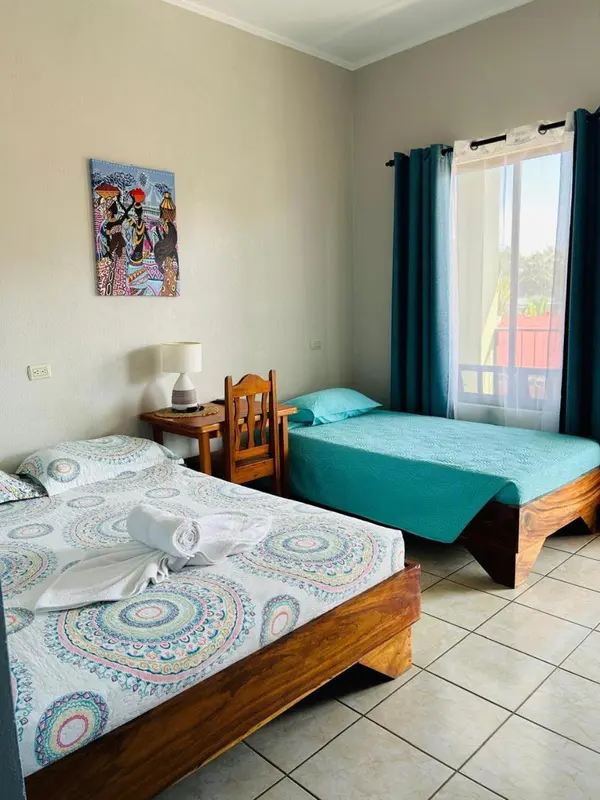Une chambre lumineuse avec deux lits simples et une décoration colorée.