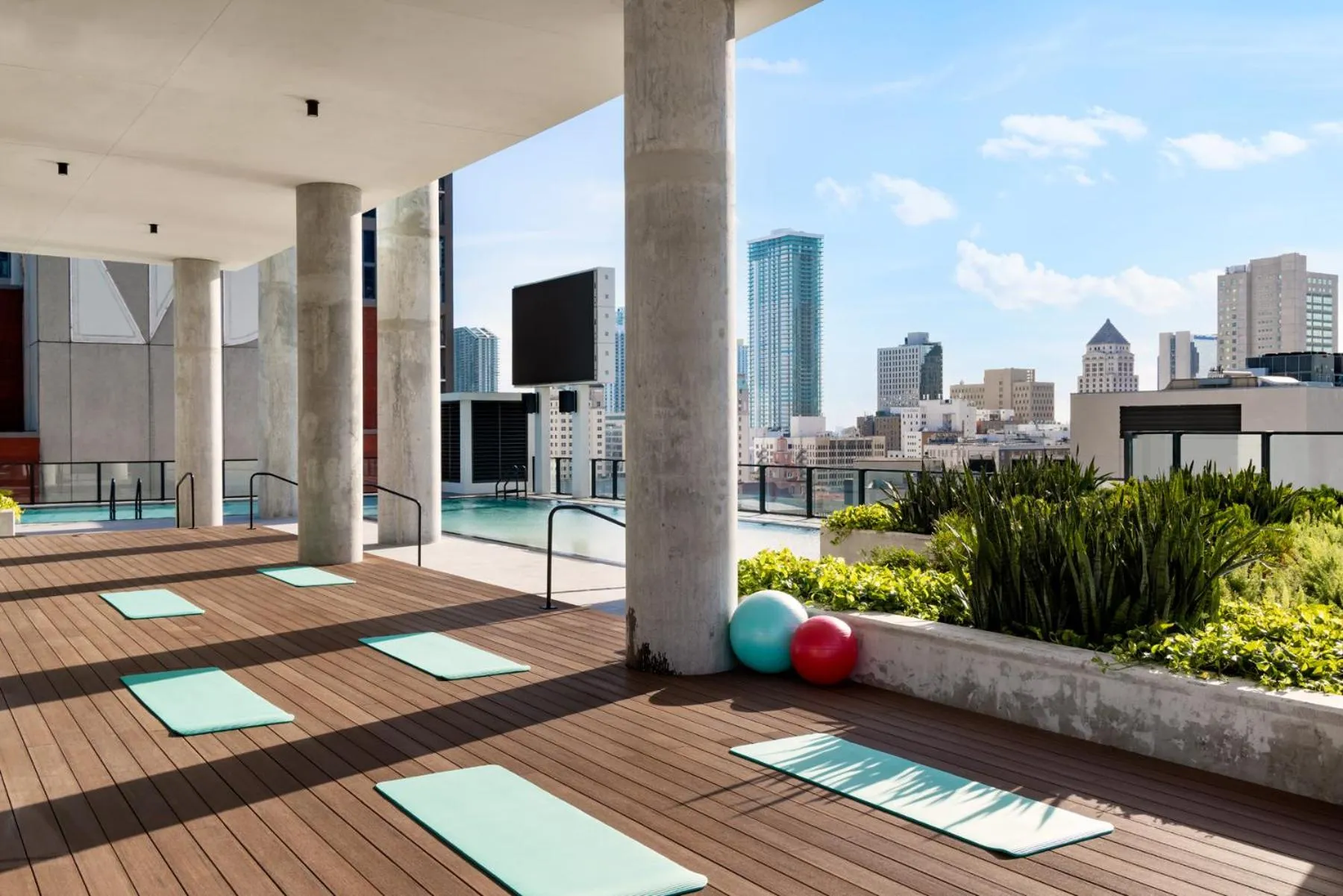 Terrasse aménagée avec tapis de sol et mobilier de détente face à une vue urbaine.
