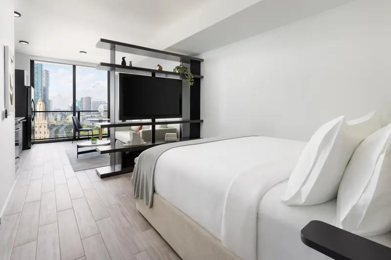 Une chambre moderne avec un grand lit et une vue sur la ville.