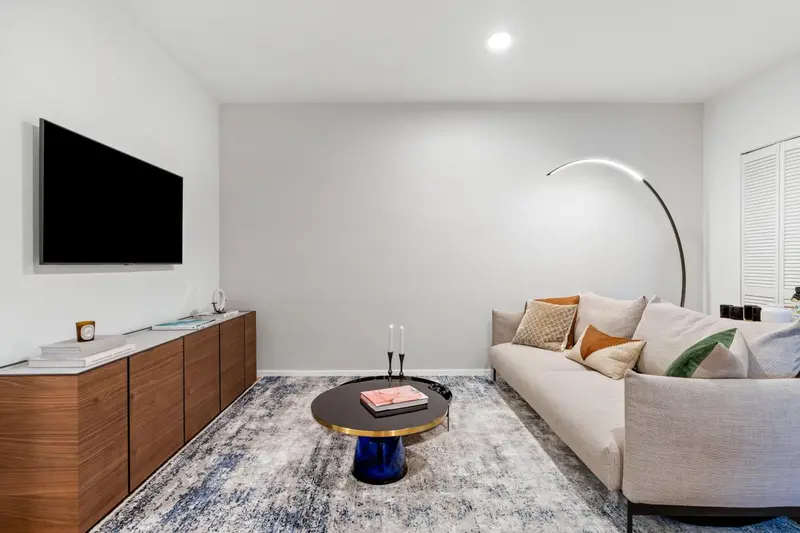 Un salon moderne avec un canapé, une télévision et une table basse.