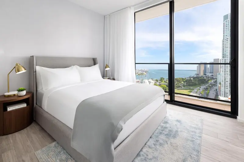 Une chambre lumineuse avec un grand lit et une vue sur la mer.