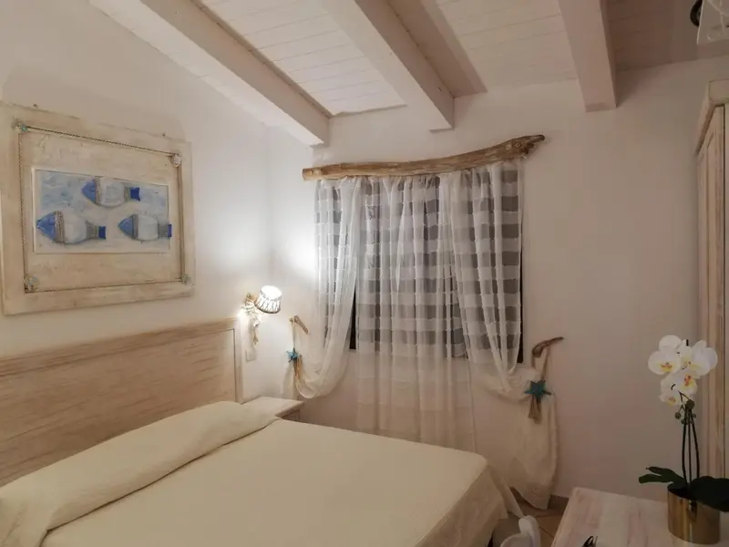 Une chambre lumineuse avec un lit et une décoration marine.