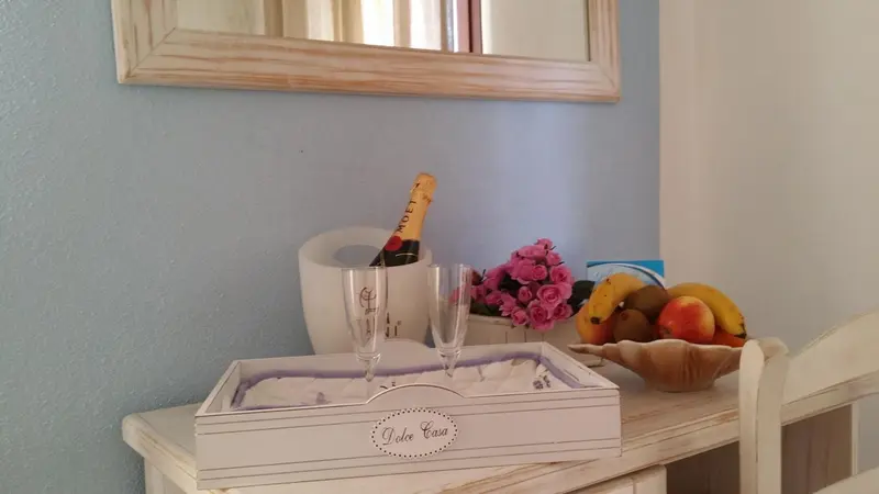 Une bouteille de champagne et des fruits frais sont disposés sur une table.