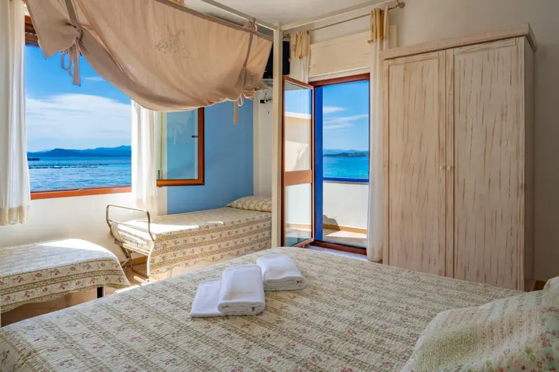 Une chambre lumineuse avec vue sur la mer et un balcon.