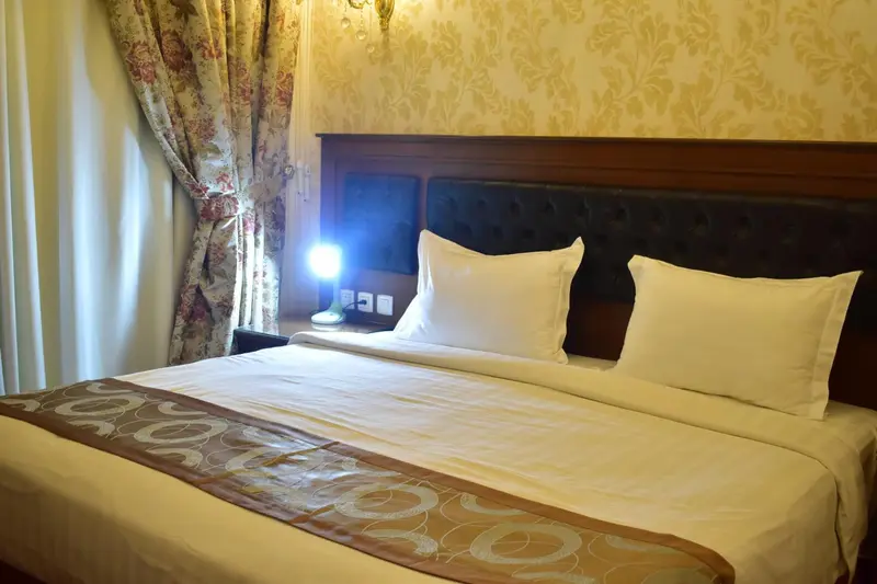 Une chambre avec un grand lit recouvert d'une courtepointe.
