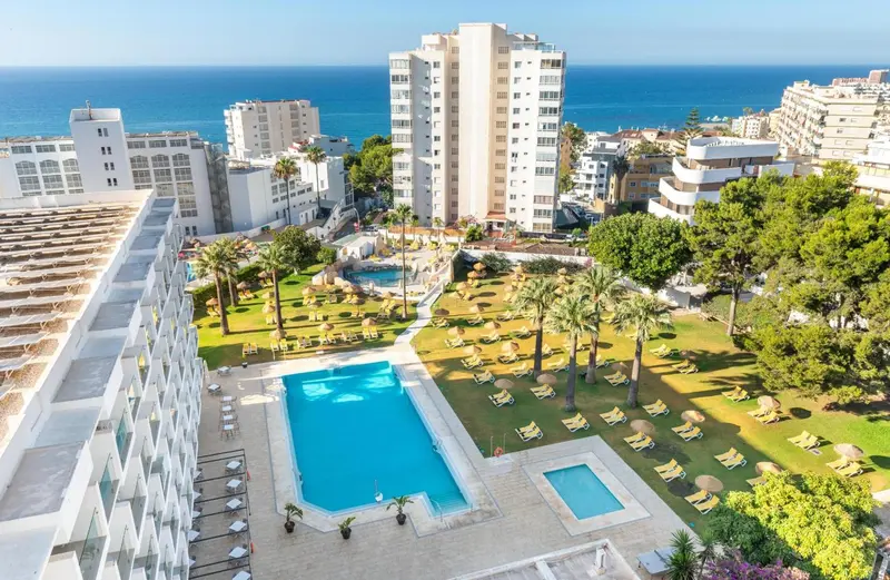 Vue aérienne d'un complexe hôtelier avec piscines et jardins luxuriants.