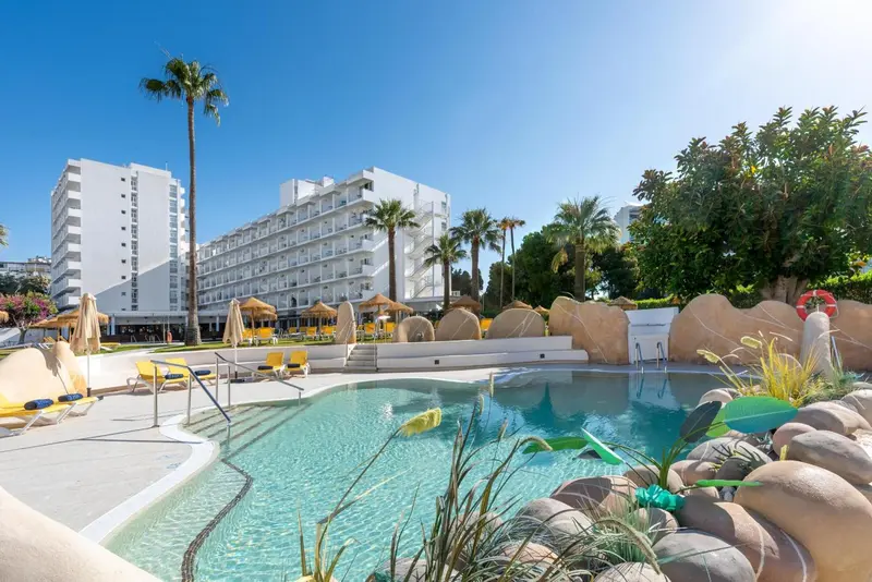 Piscine d'hôtel avec transats et végétation tropicale.