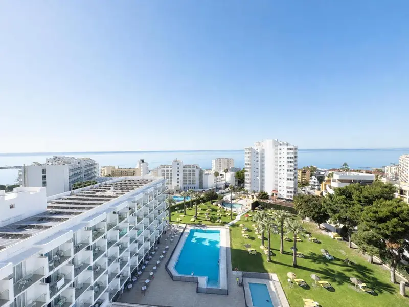 Vue aérienne d'un complexe hôtelier avec piscine et espaces verts face à la mer.