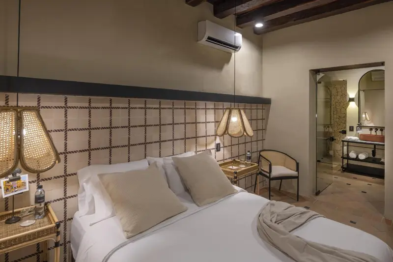 Une chambre lumineuse avec un grand lit et un accès à une salle de bain.