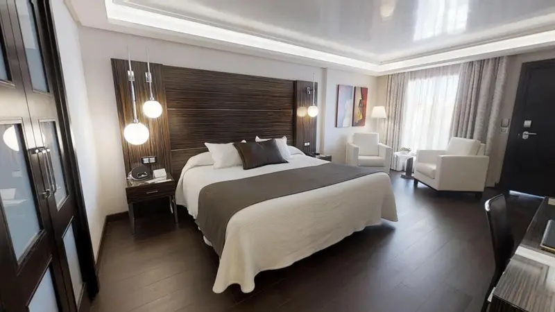 Une chambre moderne avec un grand lit et un fauteuil.