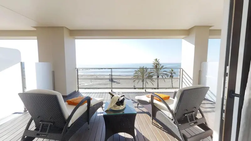 Terrasse aménagée avec mobilier d'extérieur donnant sur la mer.
