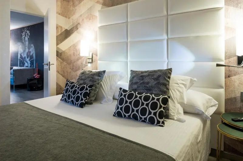 Une chambre moderne avec un grand lit et des oreillers décoratifs.