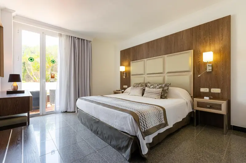 Une chambre lumineuse avec un grand lit et un accès à une terrasse.