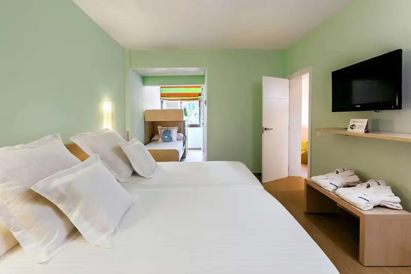 Une chambre lumineuse avec un grand lit et un espace repos.