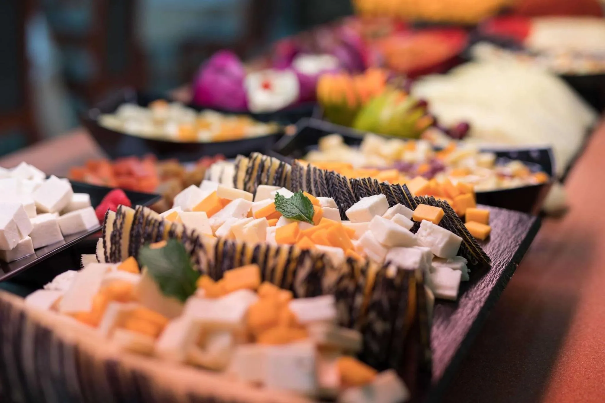 Présentation de divers plats froids et colorés sur un buffet.