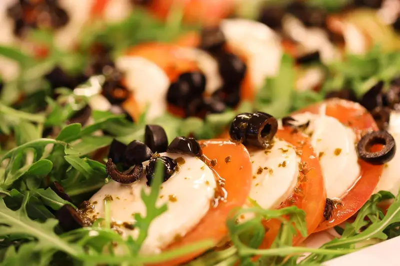 Salade colorée composée de tomates, mozzarella et olives.