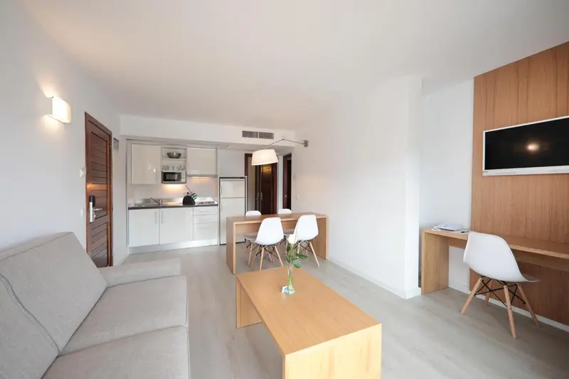 Un espace de vie lumineux avec un canapé, une table à manger et un bureau.