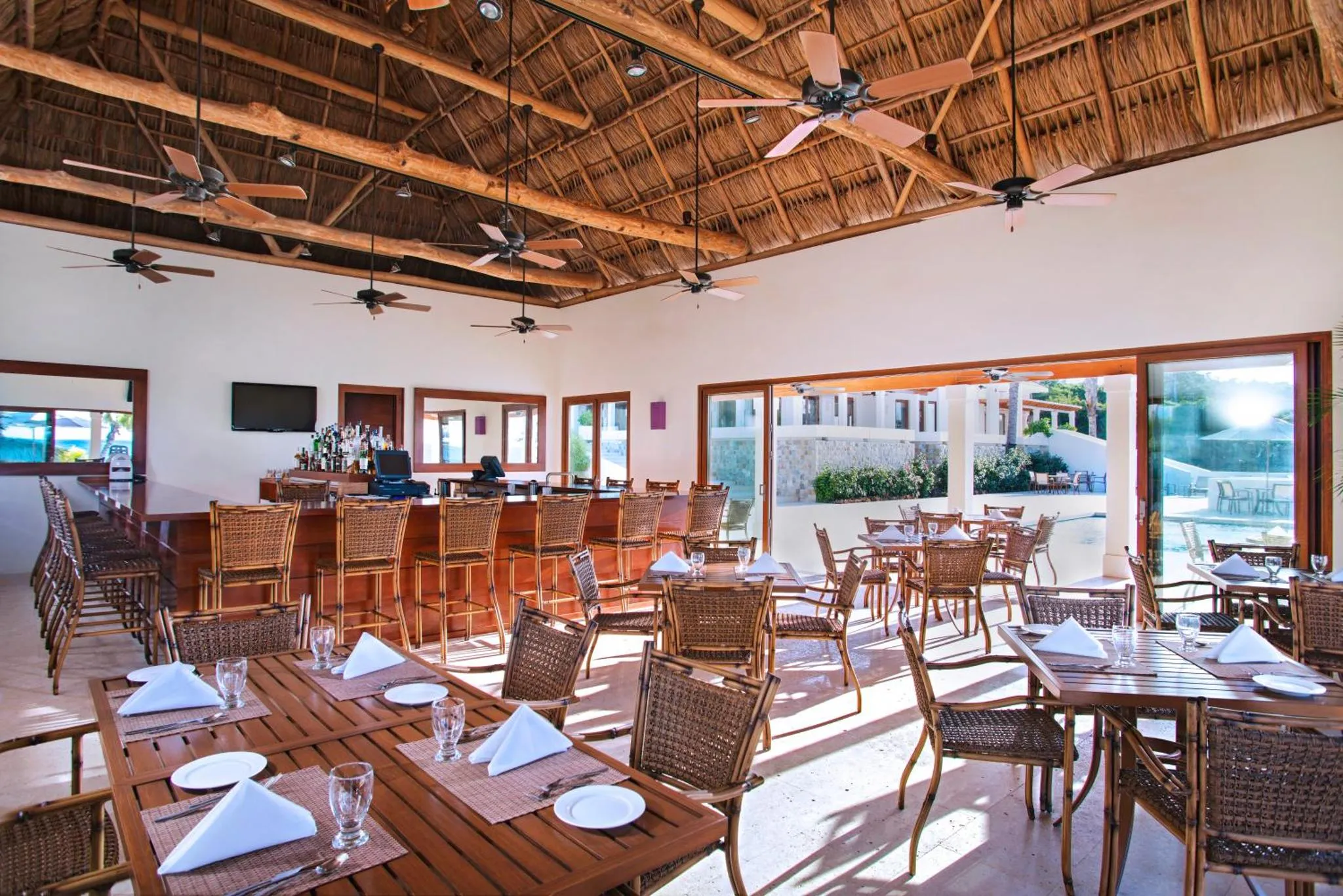 Une salle lumineuse avec un bar et des tables de restaurant.
