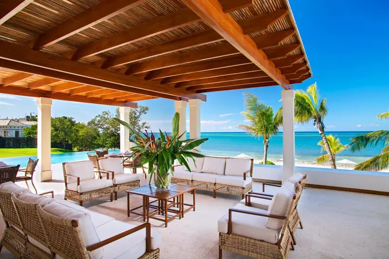 Espace de détente extérieur avec mobilier en osier et vue sur la mer.