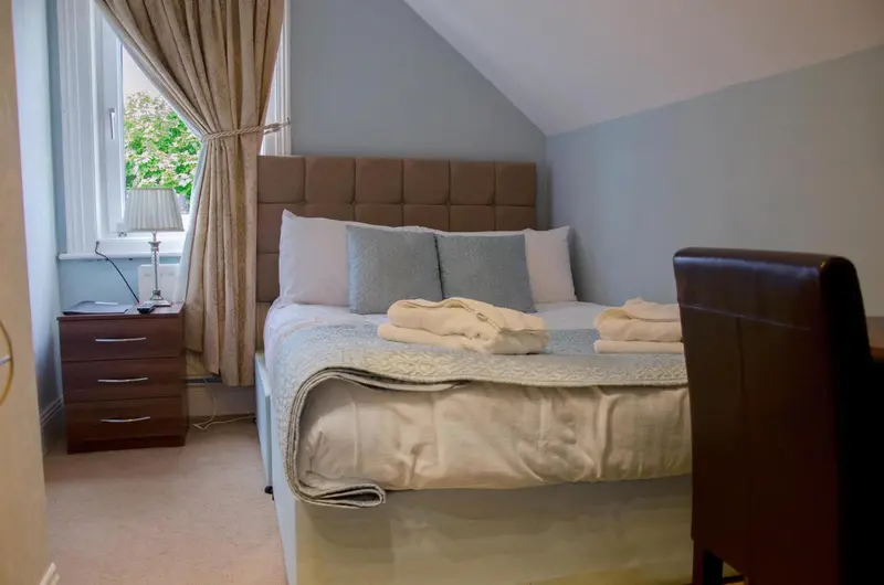 Une chambre avec un lit double et une table de chevet.