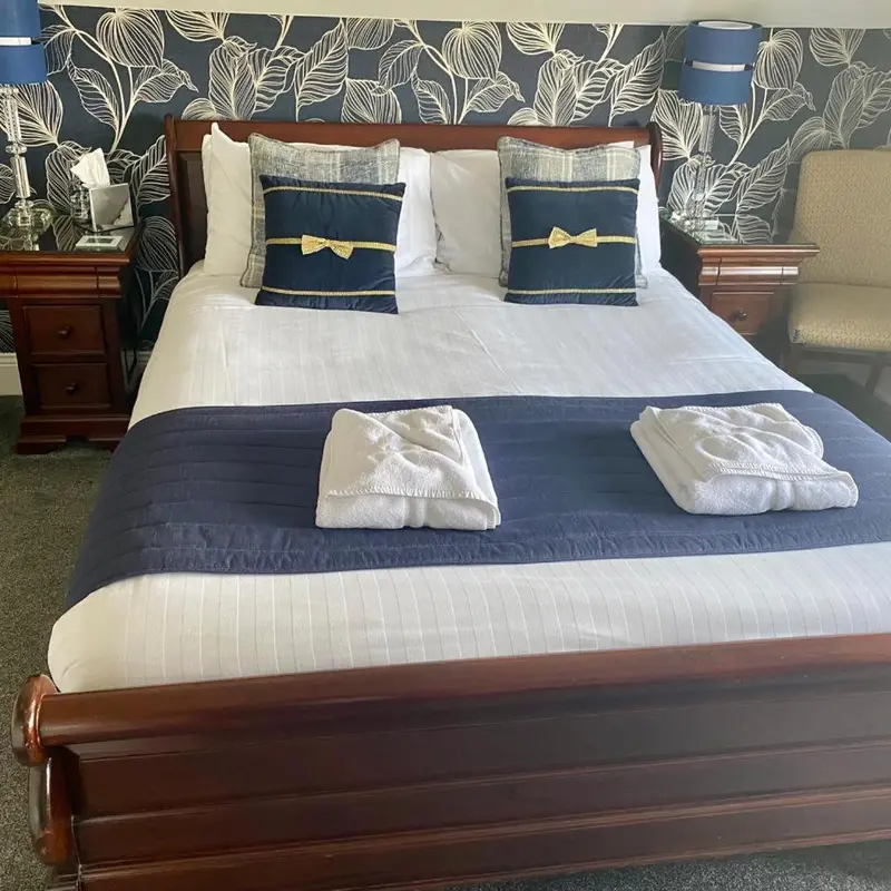 Un lit double est soigneusement fait dans une chambre décorée.