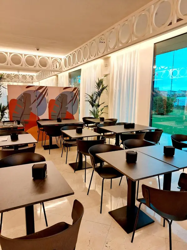 Une salle lumineuse avec des tables et des chaises disposées pour les repas.