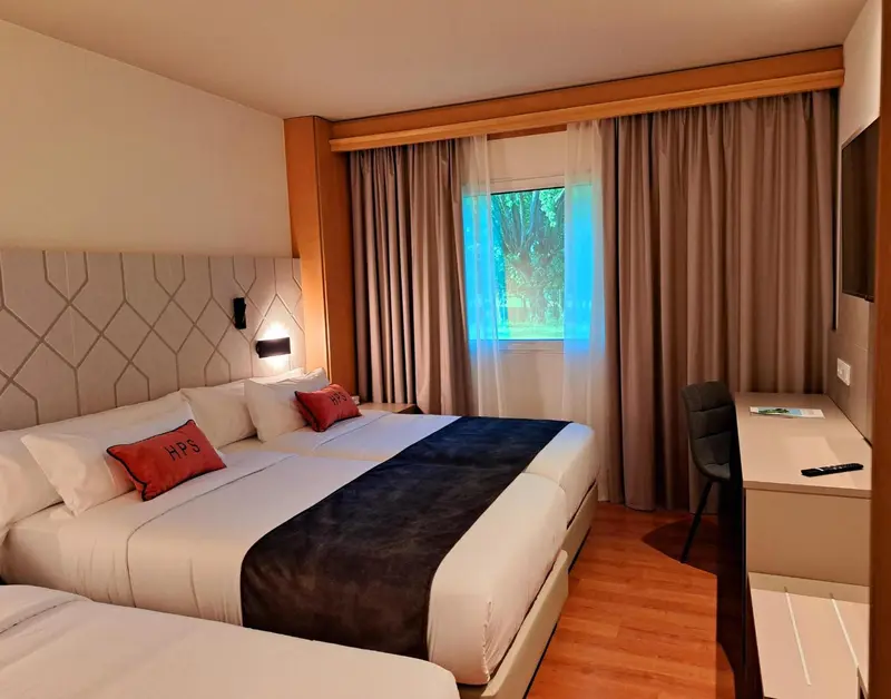 Une chambre lumineuse avec un grand lit et un bureau.