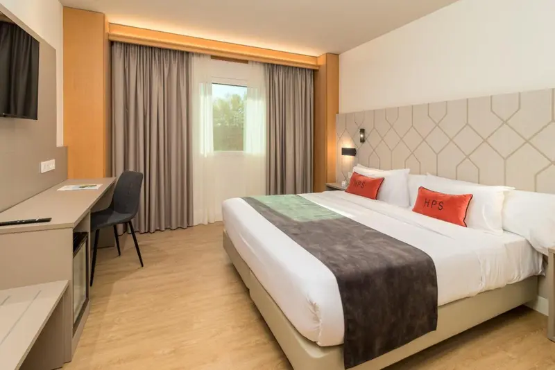 Une chambre lumineuse avec un grand lit et un bureau.