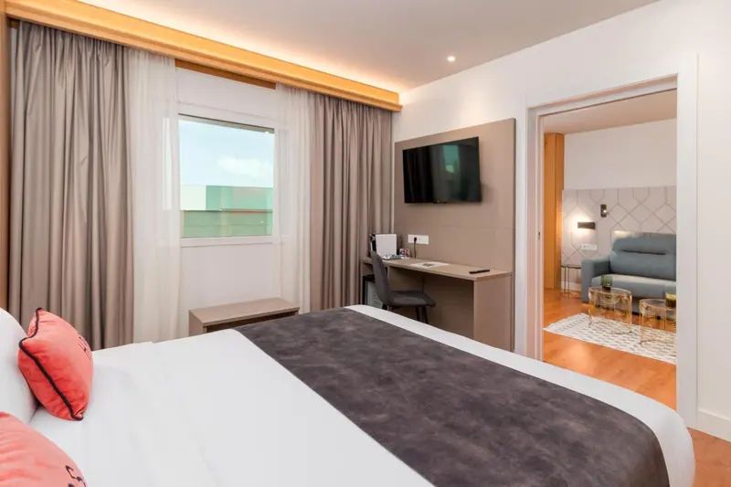Une chambre d'hôtel lumineuse avec un lit et un bureau.