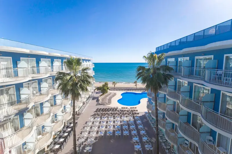 Vue aérienne d'un complexe hôtelier avec piscine et accès à la plage.