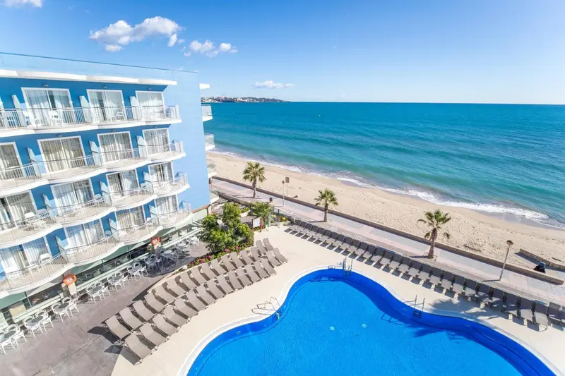 Vue aérienne d'un complexe hôtelier avec piscine et accès à la plage.