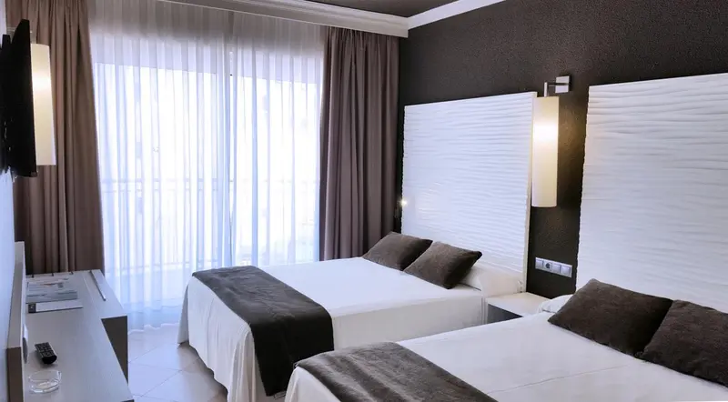Une chambre moderne avec deux lits simples et de grandes fenêtres.