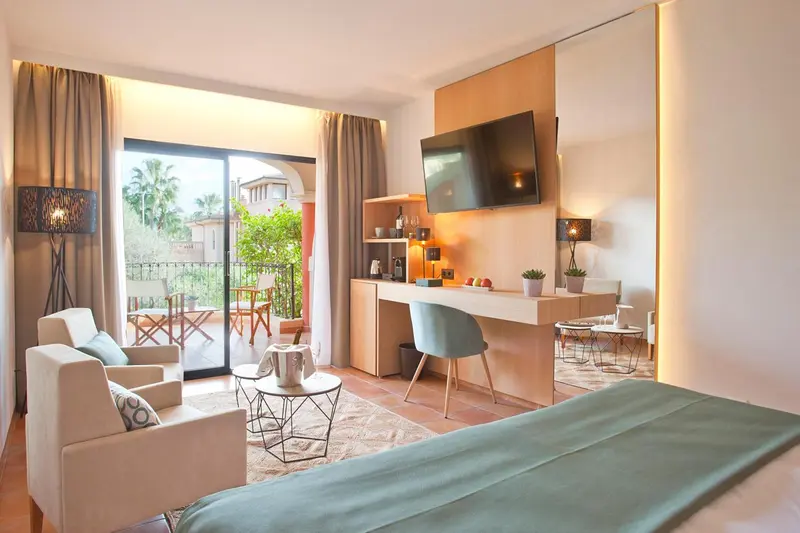 Une chambre lumineuse avec un coin salon et un accès à une terrasse.