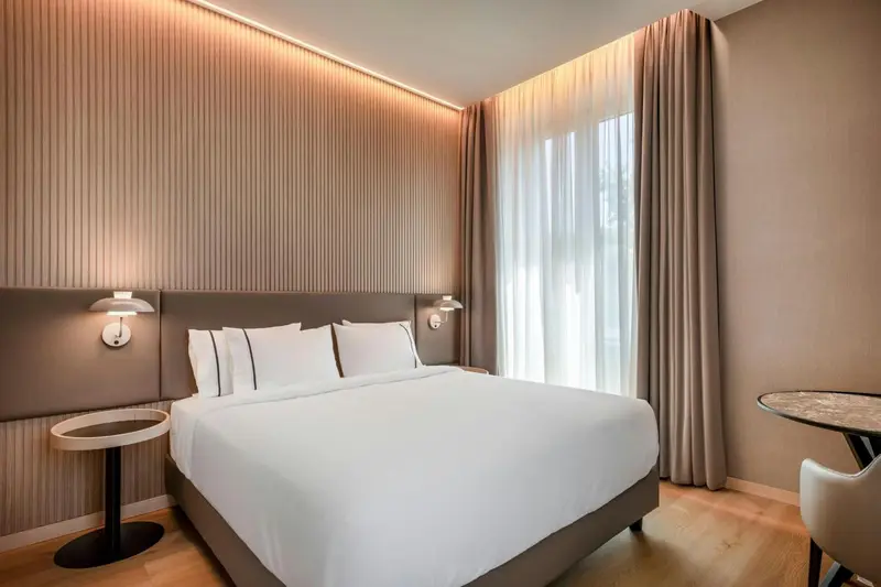 Une chambre d'hotel moderne avec un grand lit et des rideaux.