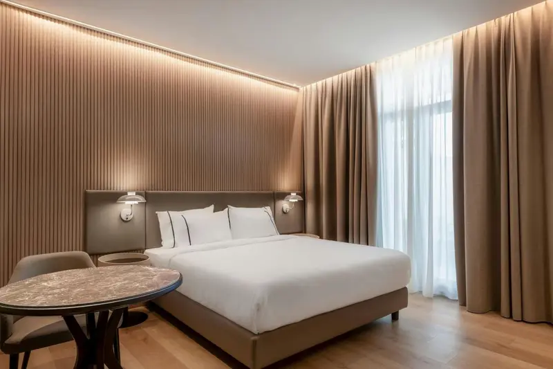 Une chambre moderne avec un grand lit et une table d'appoint.