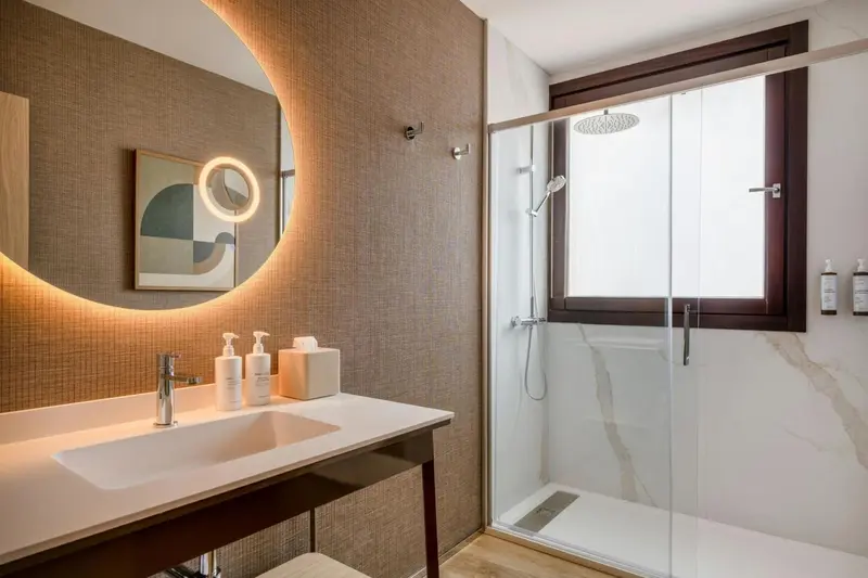 Une salle de bain moderne avec douche à l'italienne et grand miroir.