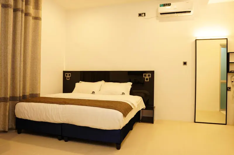Une chambre lumineuse avec un grand lit et un miroir.