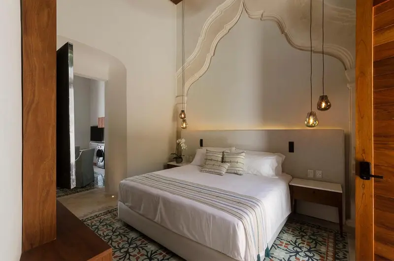 Une chambre lumineuse avec un grand lit et une décoration murale sculptée.