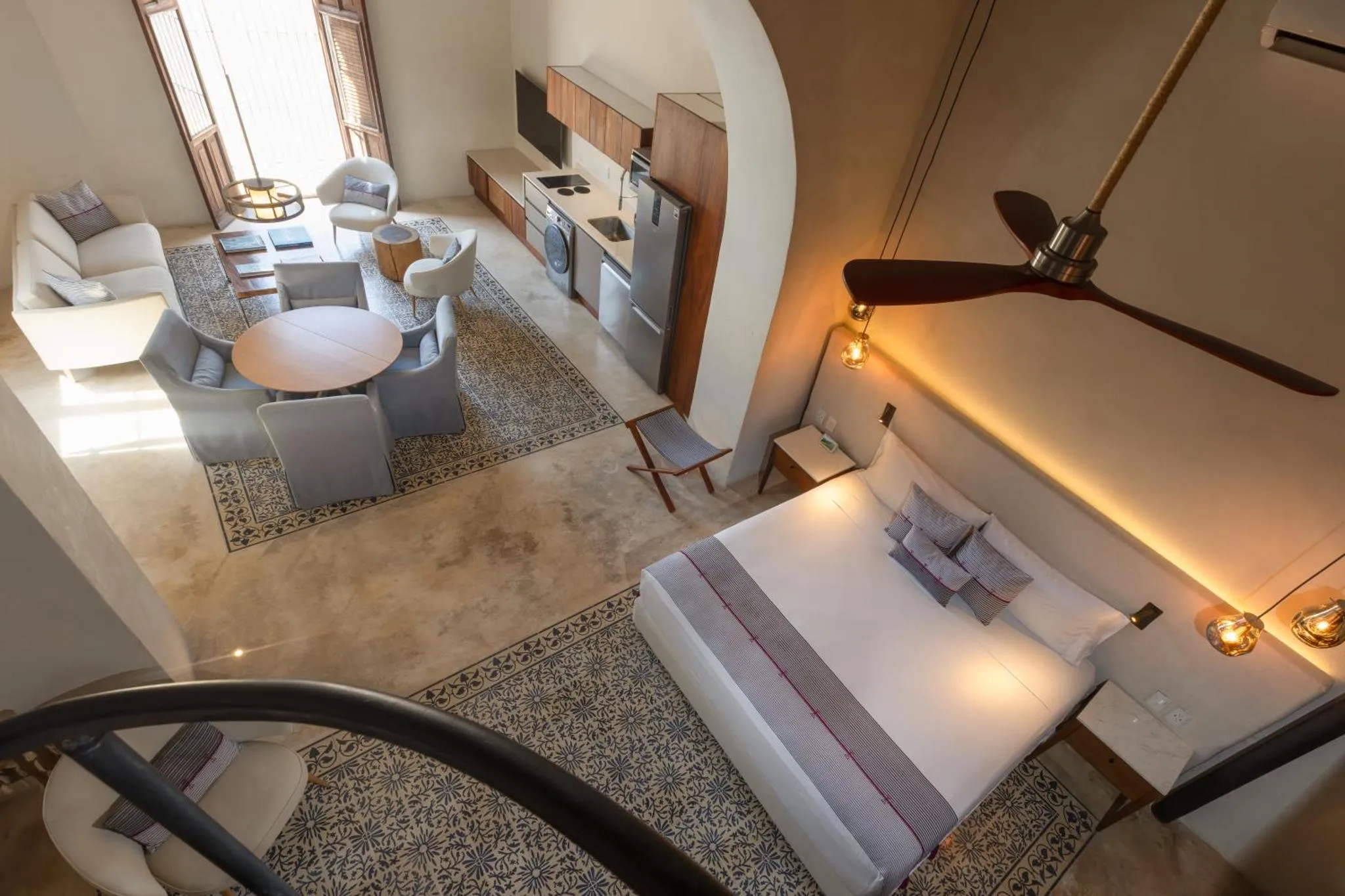 Vue d'ensemble d'un espace de vie avec coin salon, cuisine et chambre à coucher.