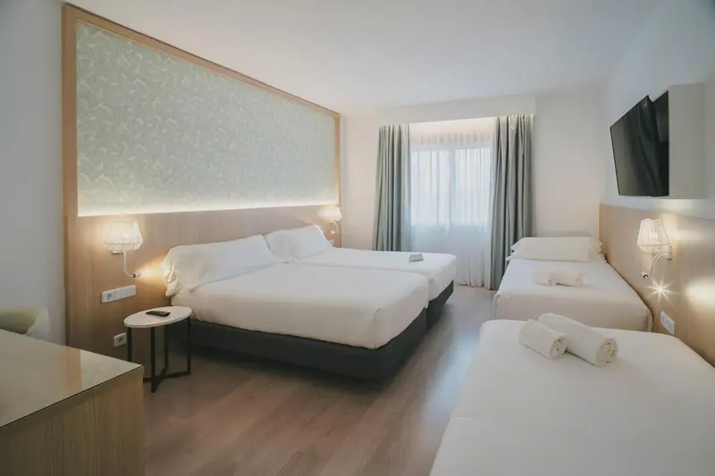Chambre d'hôtel avec deux lits doubles et une fenêtre.