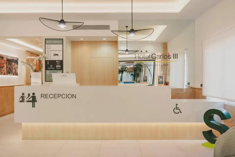 Un comptoir d'accueil moderne dans un hall d'hôtel clair et spacieux.