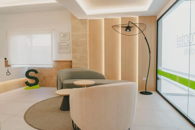 Espace d'attente moderne avec canapés et éclairage design.
