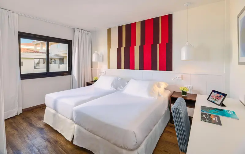 Une chambre lumineuse avec un grand lit et une décoration moderne.