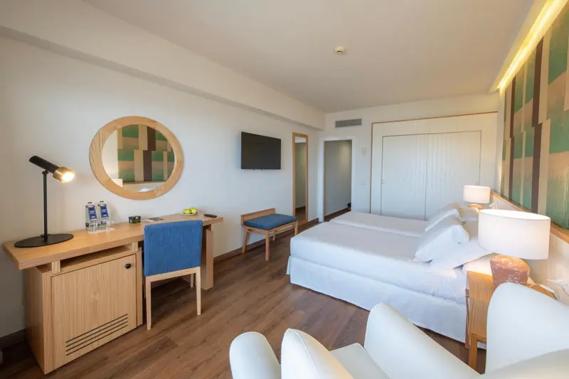 Une chambre lumineuse avec un bureau et un lit double.