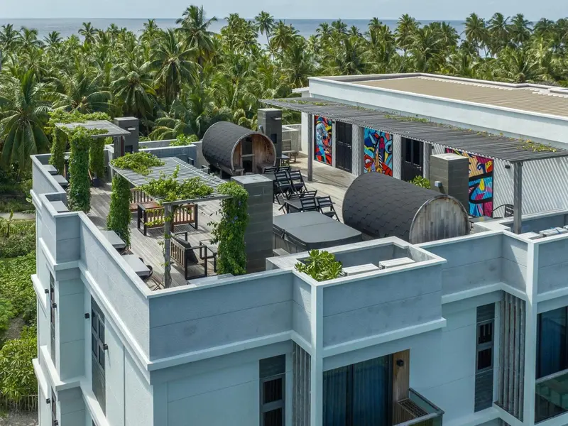 Terrasse aménagée avec mobilier de jardin et structures ajourées.