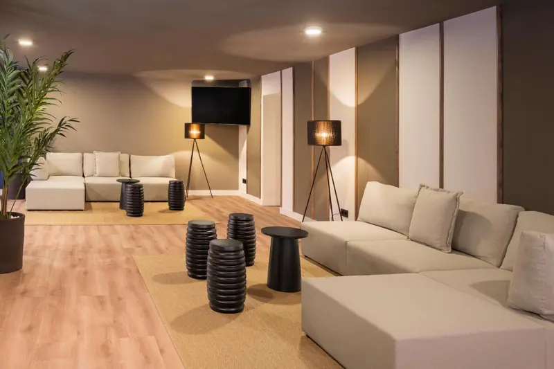 Espace de détente intérieur avec canapés et éclairages design.